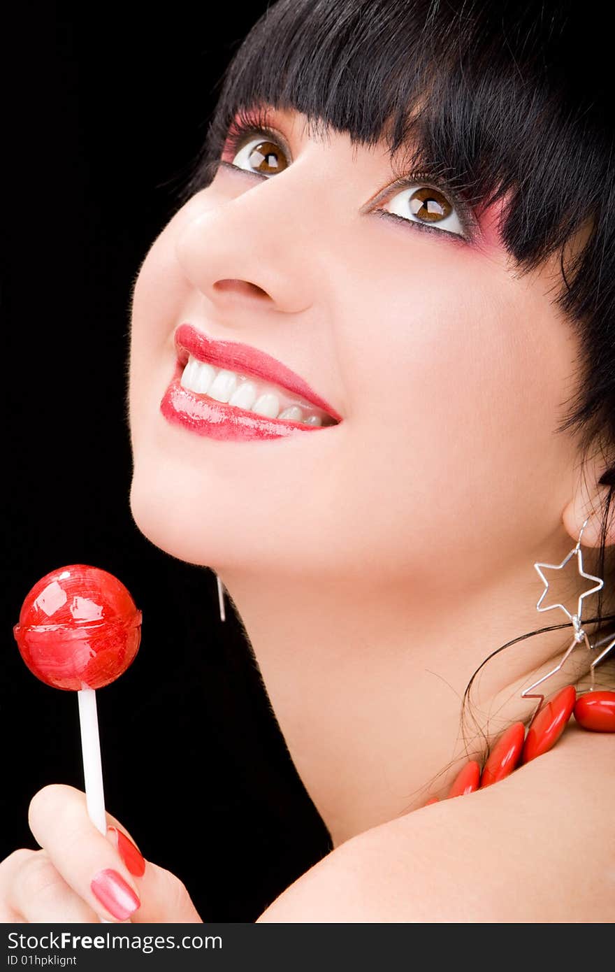 Sweet woman with candy on black background