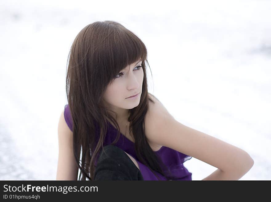 Picture of a girl who lies on the snow in the purple dress. Picture of a girl who lies on the snow in the purple dress