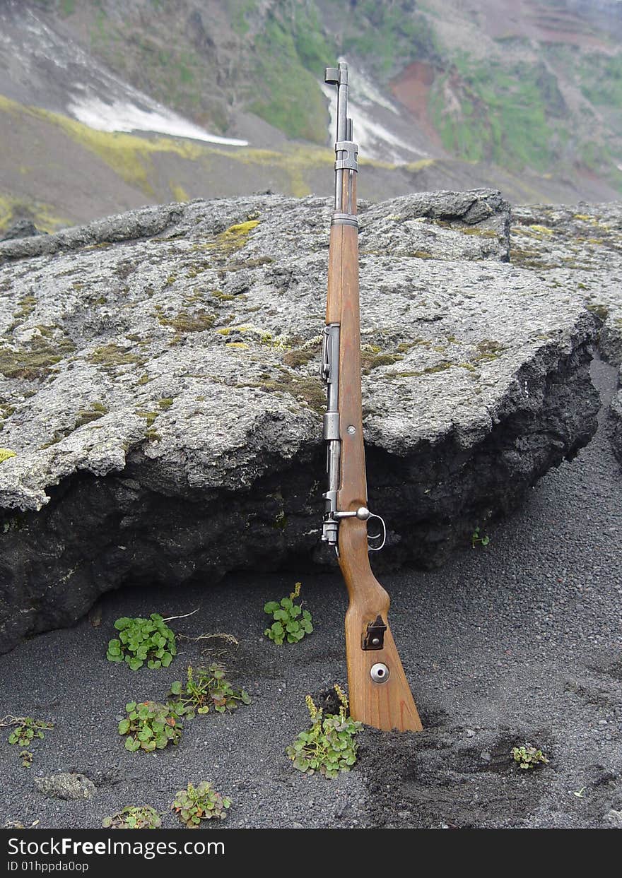 Rifle on the black beach of Jan Mayen island