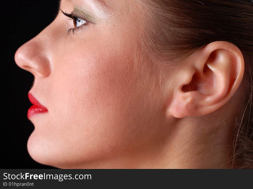 Profile of a beautiful young woman at black background. Profile of a beautiful young woman at black background