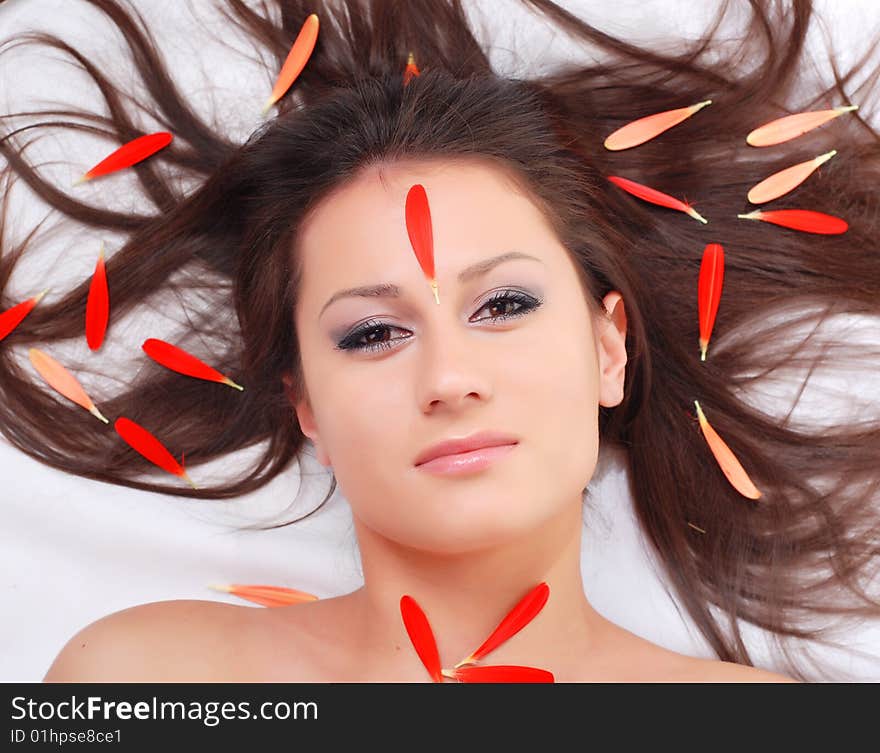 Portrait of a beautiful woman with red petals