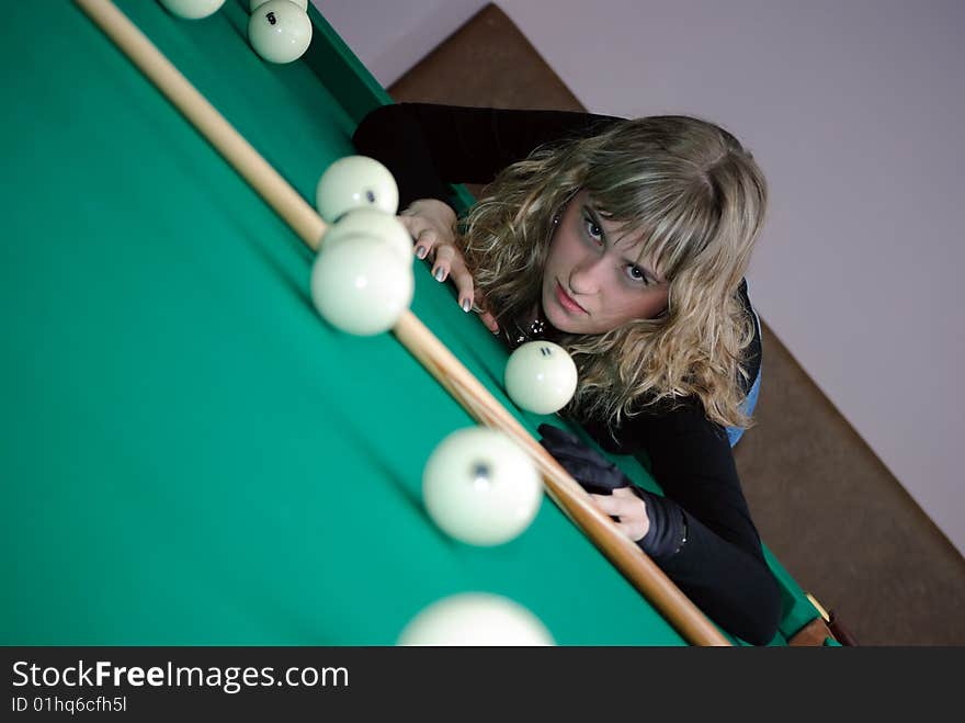 The girl with a passionate sight lays on a billiard table. The girl with a passionate sight lays on a billiard table