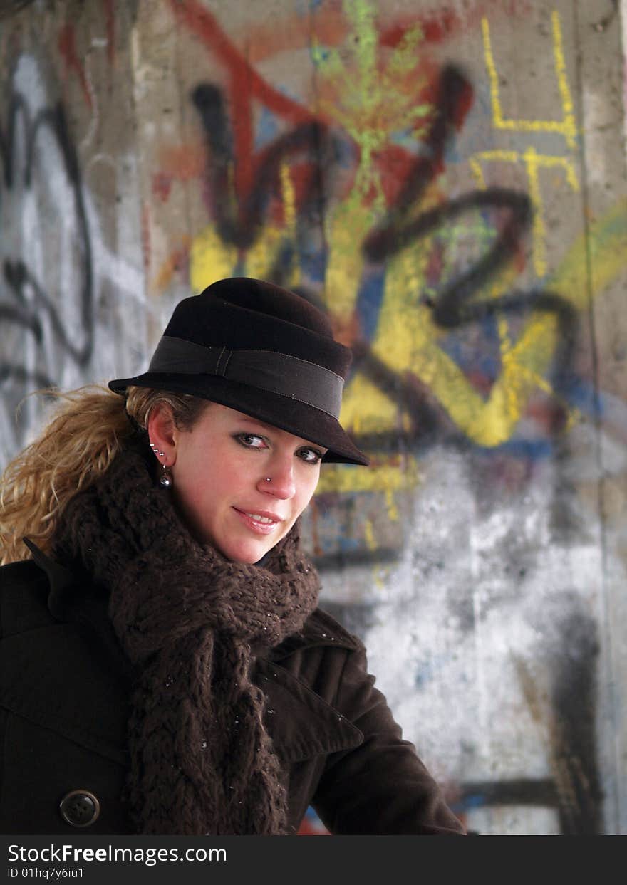 Girl with brown hat with graffiti background behind