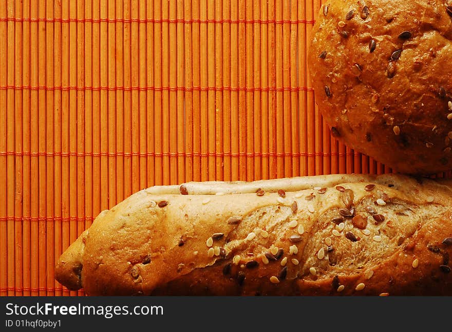 Fresh bread over orange bamboo mat. Fresh bread over orange bamboo mat