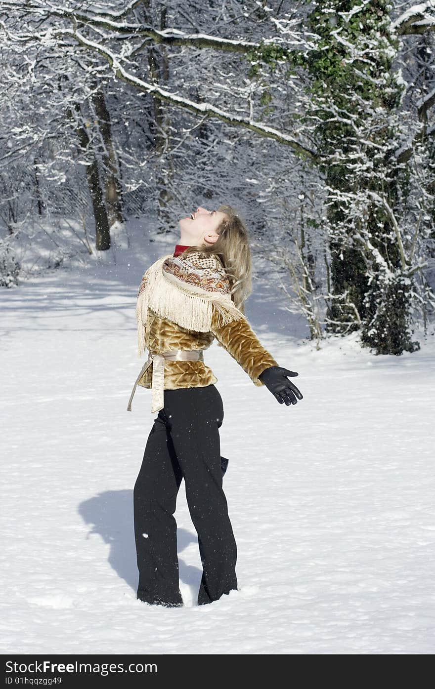 A young women is playing in a garden in winter. A young women is playing in a garden in winter