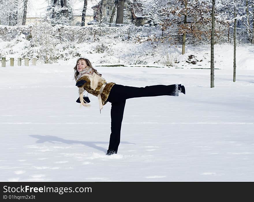 A young woman is playing in a garden in winter. A young woman is playing in a garden in winter