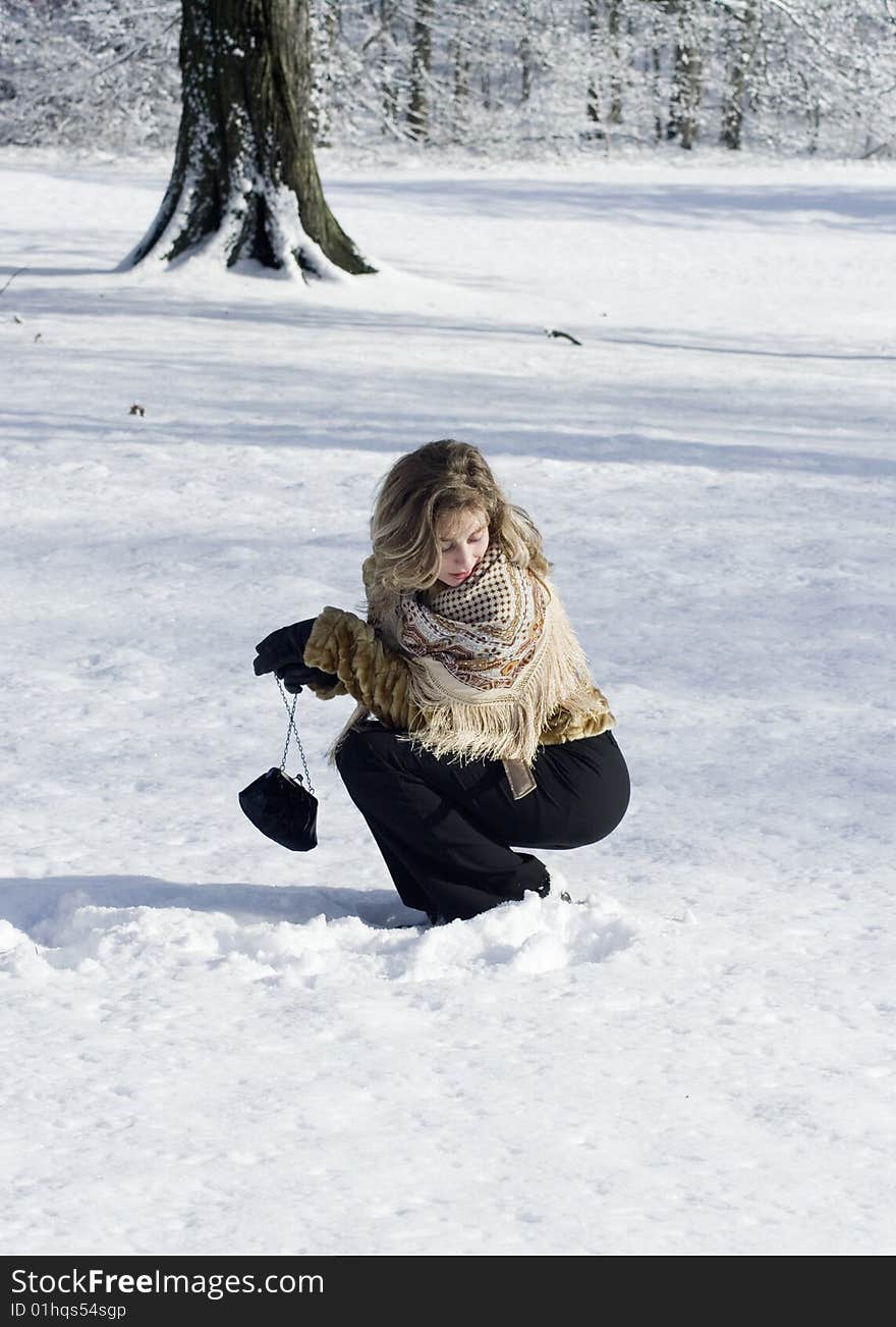 A young women is playing in a garden in winter