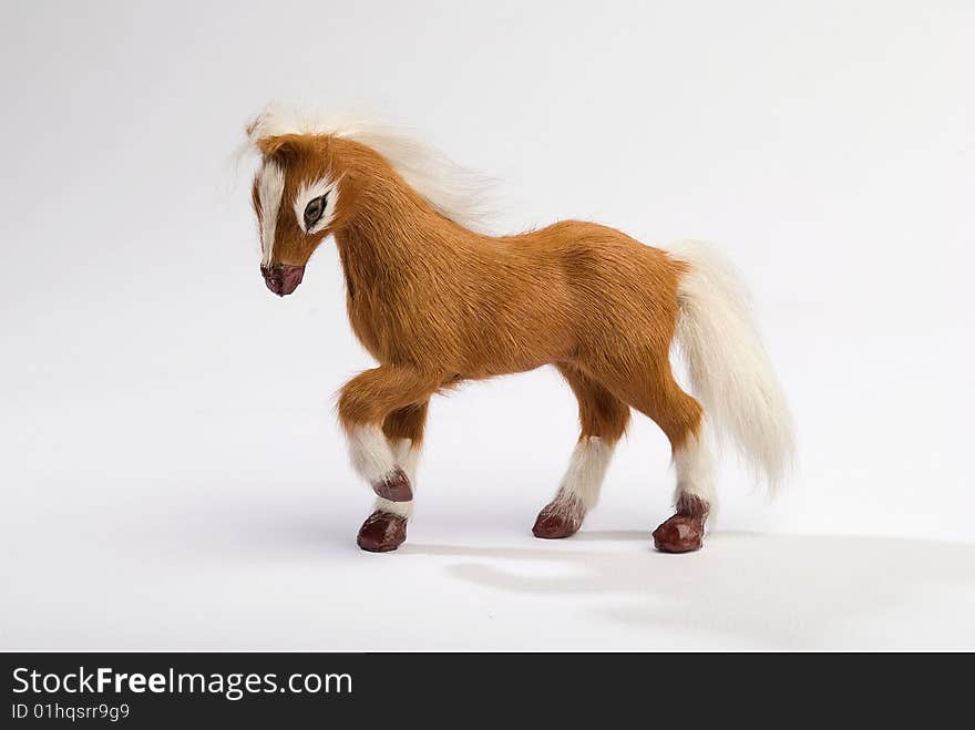 Cute horse toy with beautiful mane prancing on white background. Cute horse toy with beautiful mane prancing on white background