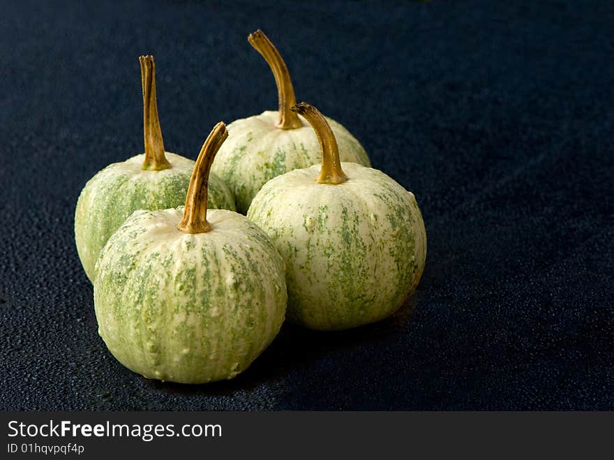 4 pumpkins on a table in rain-drops. 4 pumpkins on a table in rain-drops