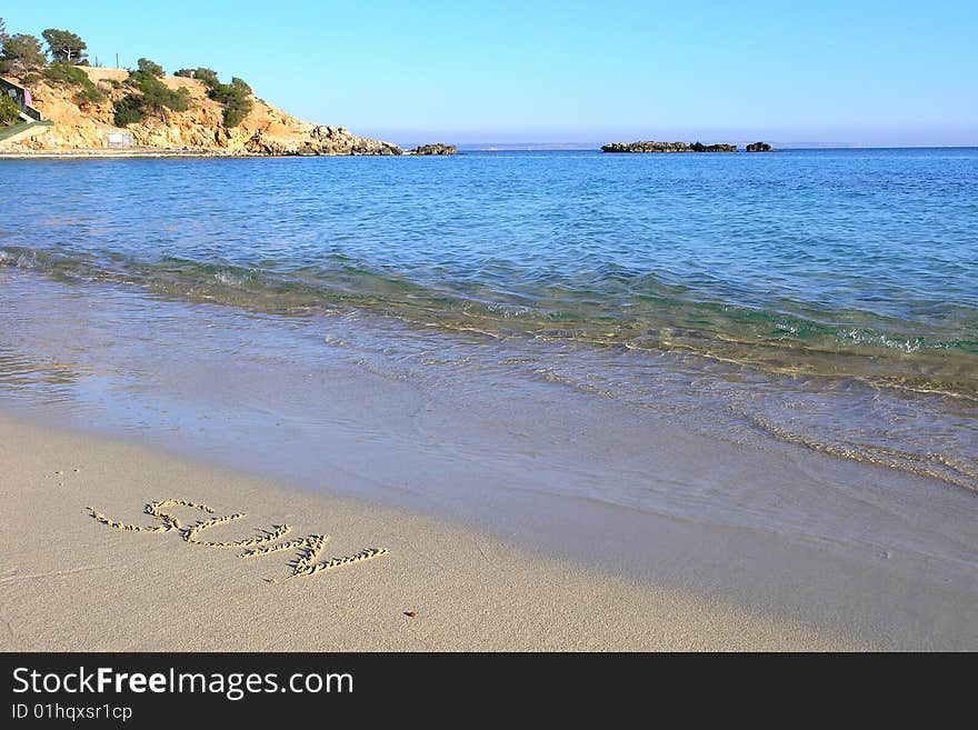 Sun written in the sand on tropical beach with sea. Sun written in the sand on tropical beach with sea