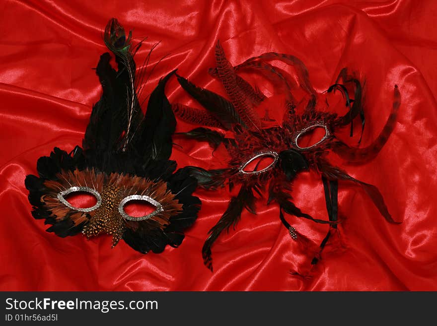 Two carmival masks on red silk. Two carmival masks on red silk