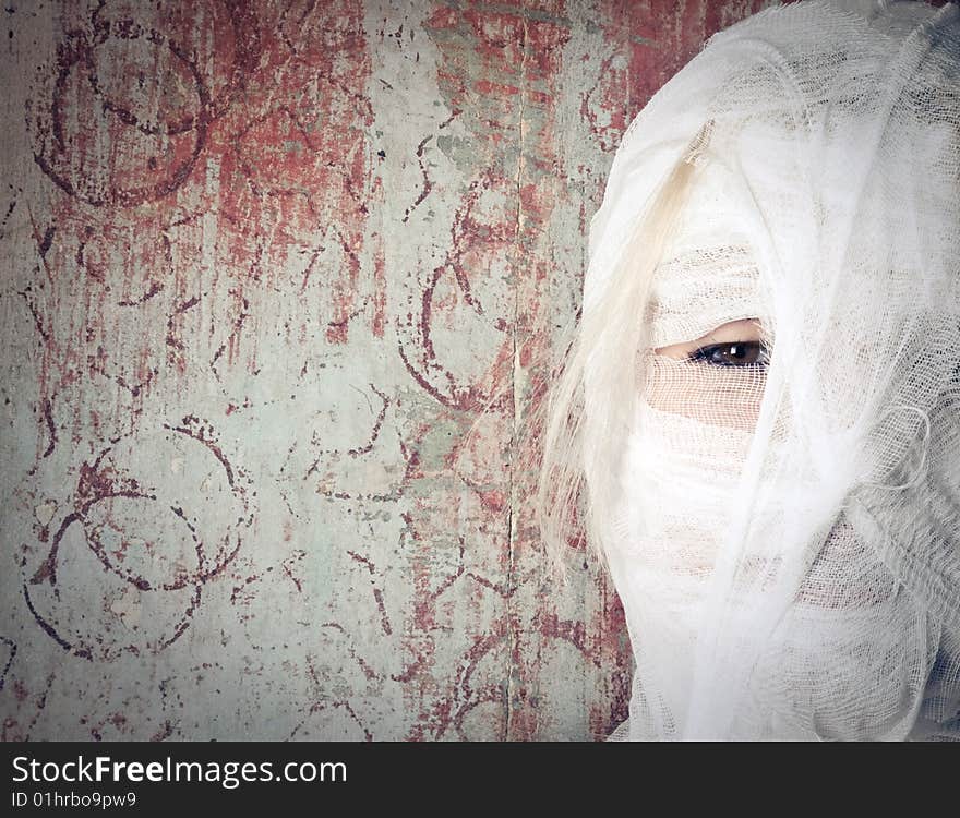 Woman in bandage on the dirty background looking at the camera