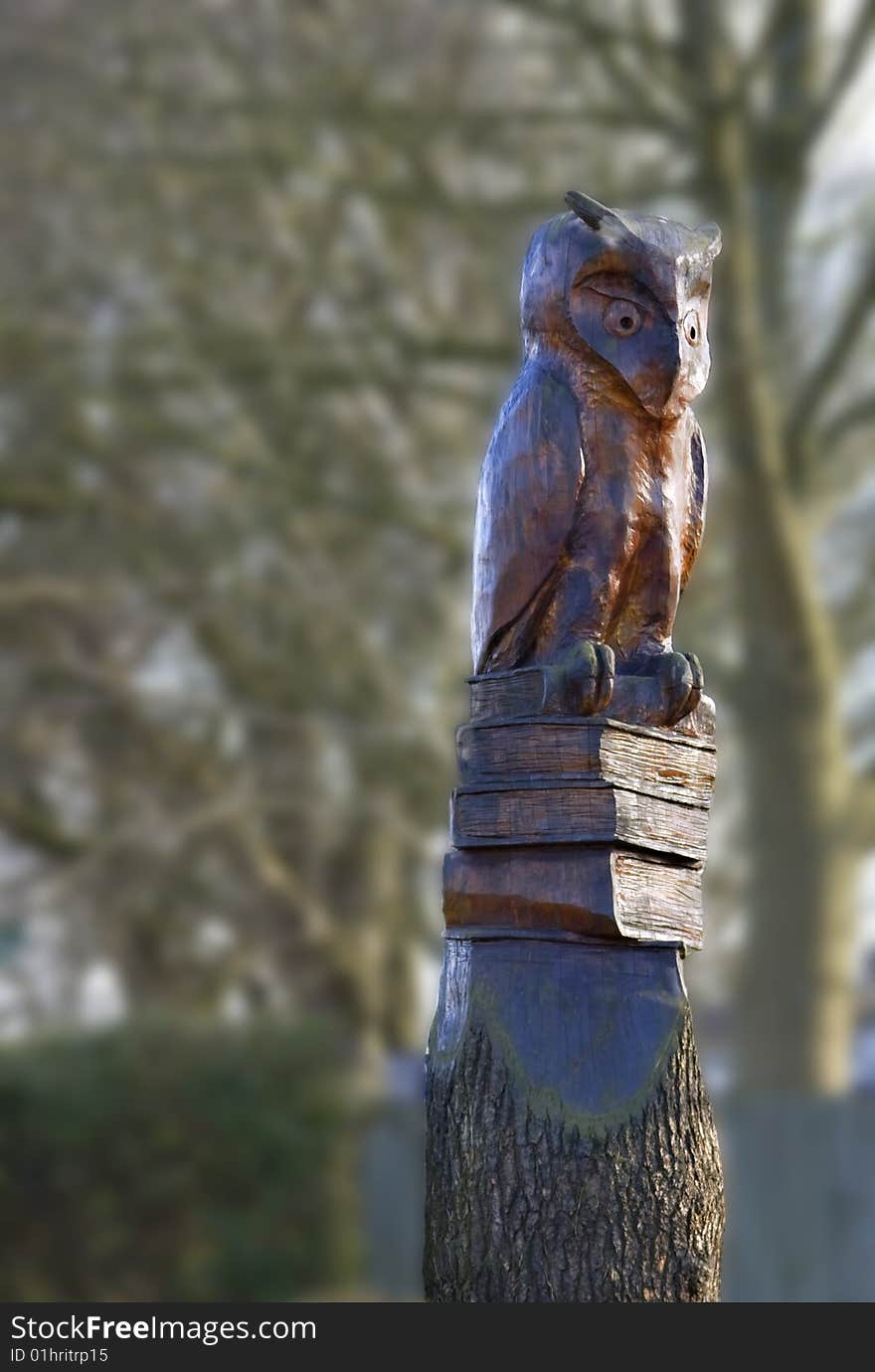 Felled tree carved into a statue of a wise old owl. Felled tree carved into a statue of a wise old owl