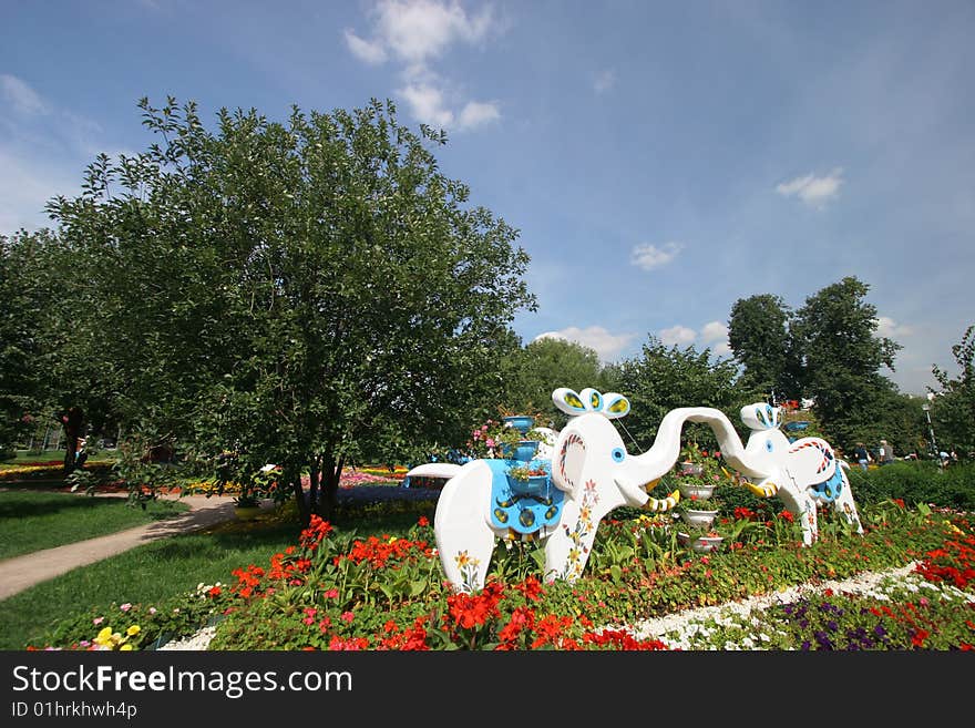 Flower bed in park. Sculptures of elephants. Flower bed in park. Sculptures of elephants