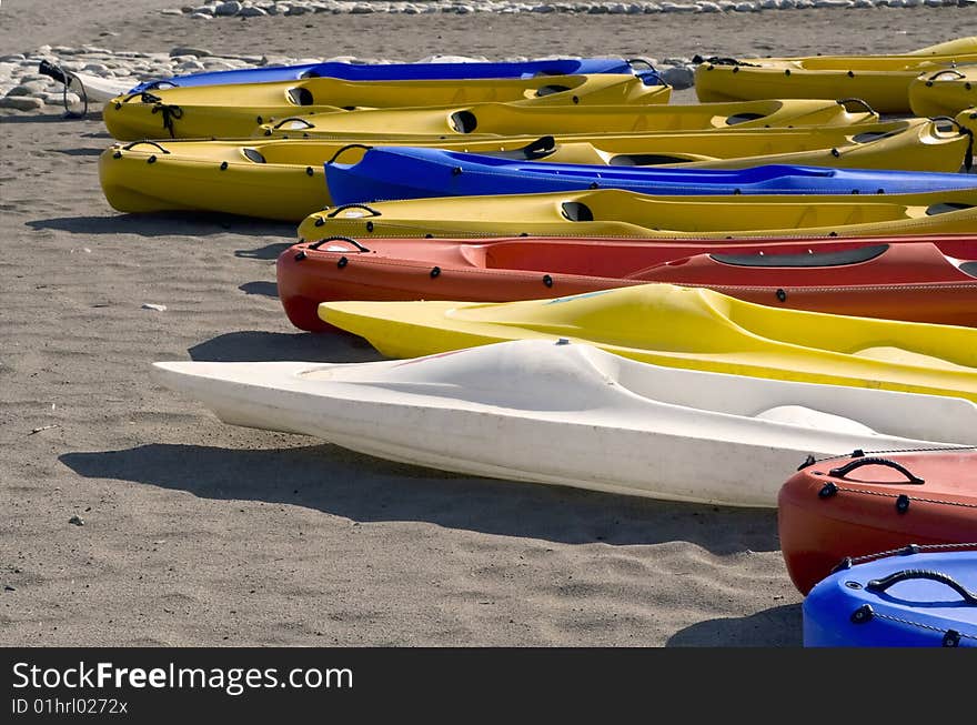 Colourful Canoes Lie On Sand