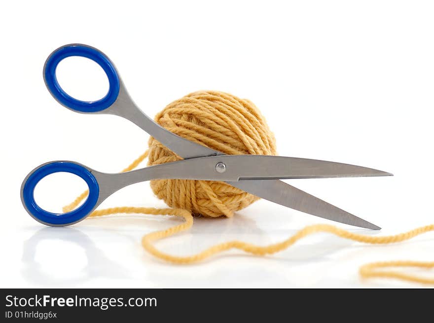 Ball with yarn and scissors against the white background