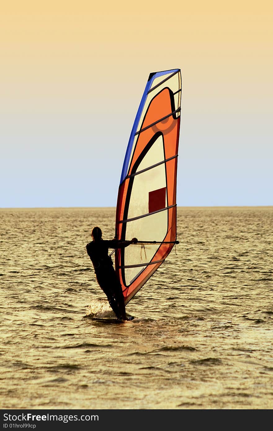 Silhouette of a windsurfer on waves of a sea