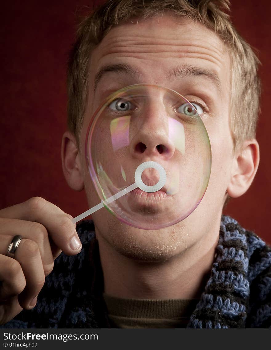 Handsome young blonde man blowing a bubble. Handsome young blonde man blowing a bubble