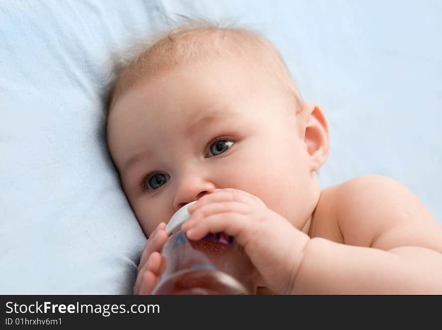 Adorable little girl drinking from plastic bottle