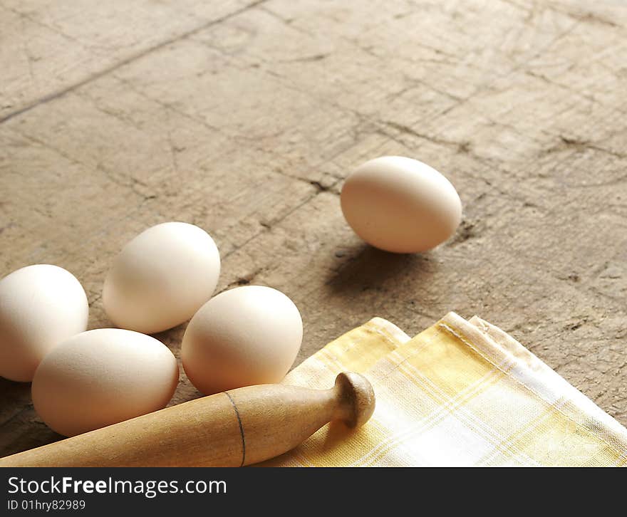 Some eggs and dishcloth on very old wooden table