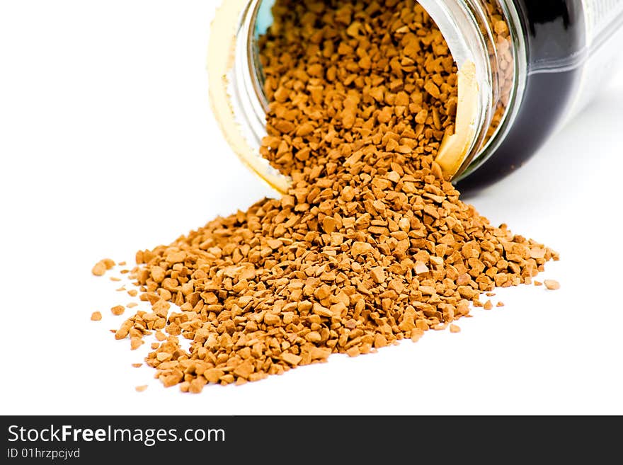 Instant coffee granules spilled from container on white