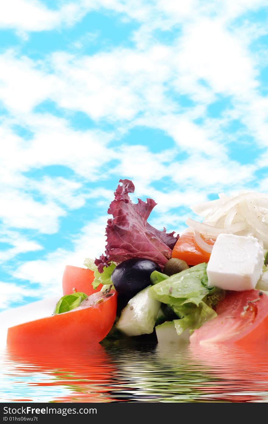 Greek Salad with Tomato and Onions on a Blue Sky Background