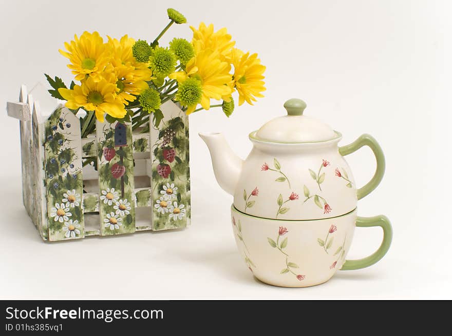 Teapot next to bouquet of yellow flowers