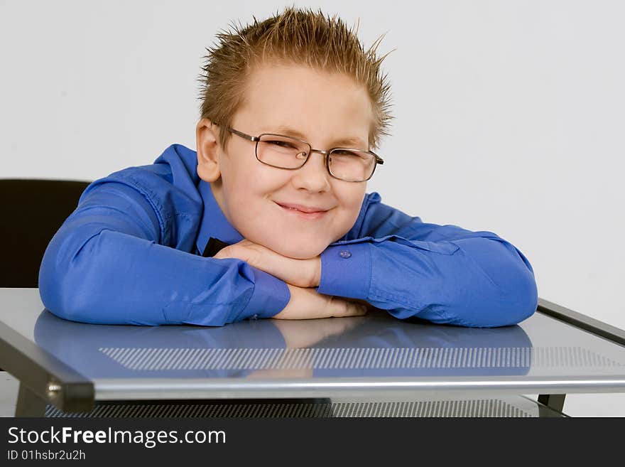 Funny schoolboy leaning on school desk