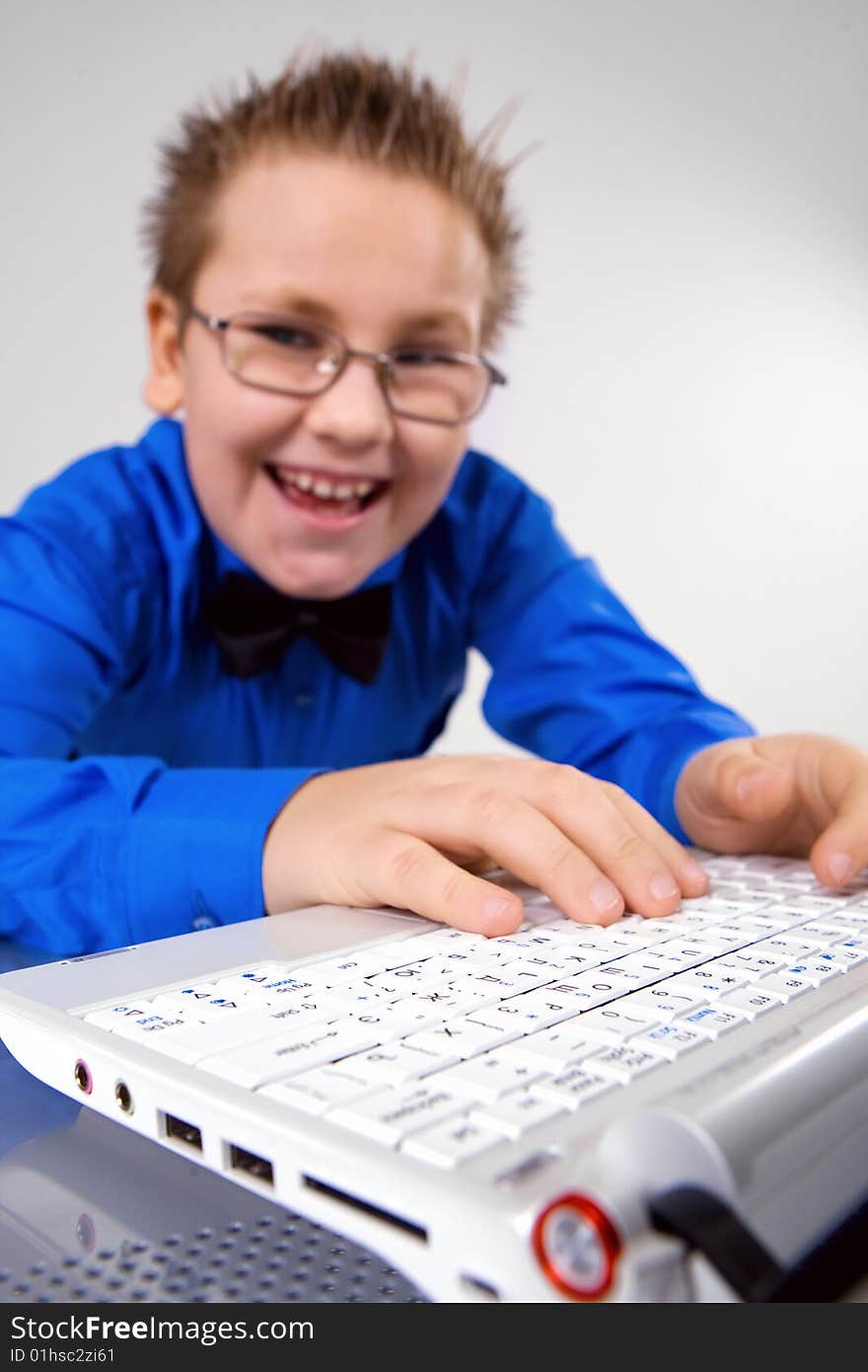 Funny school boy with laptop isolated on white