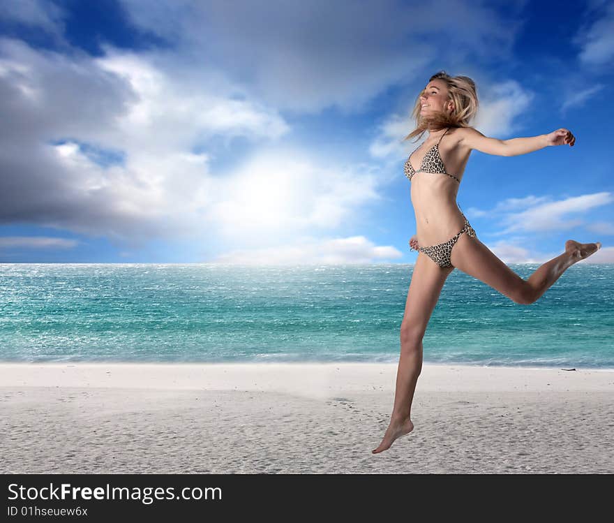 A young pretty girl in bikini running on the beach