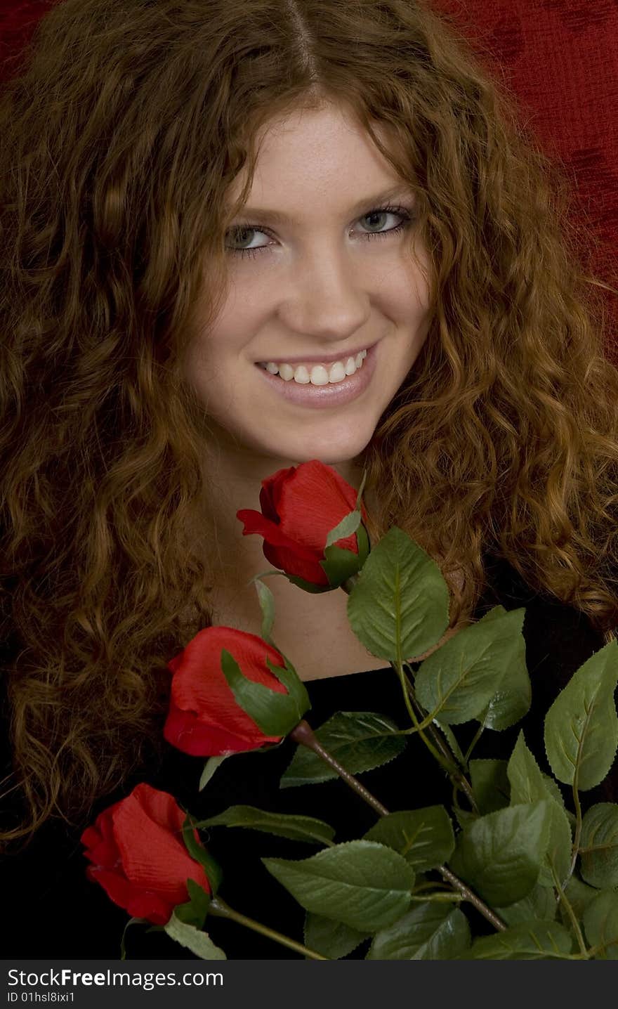 Red haired teenager with red roses, attractive youthful with long hair