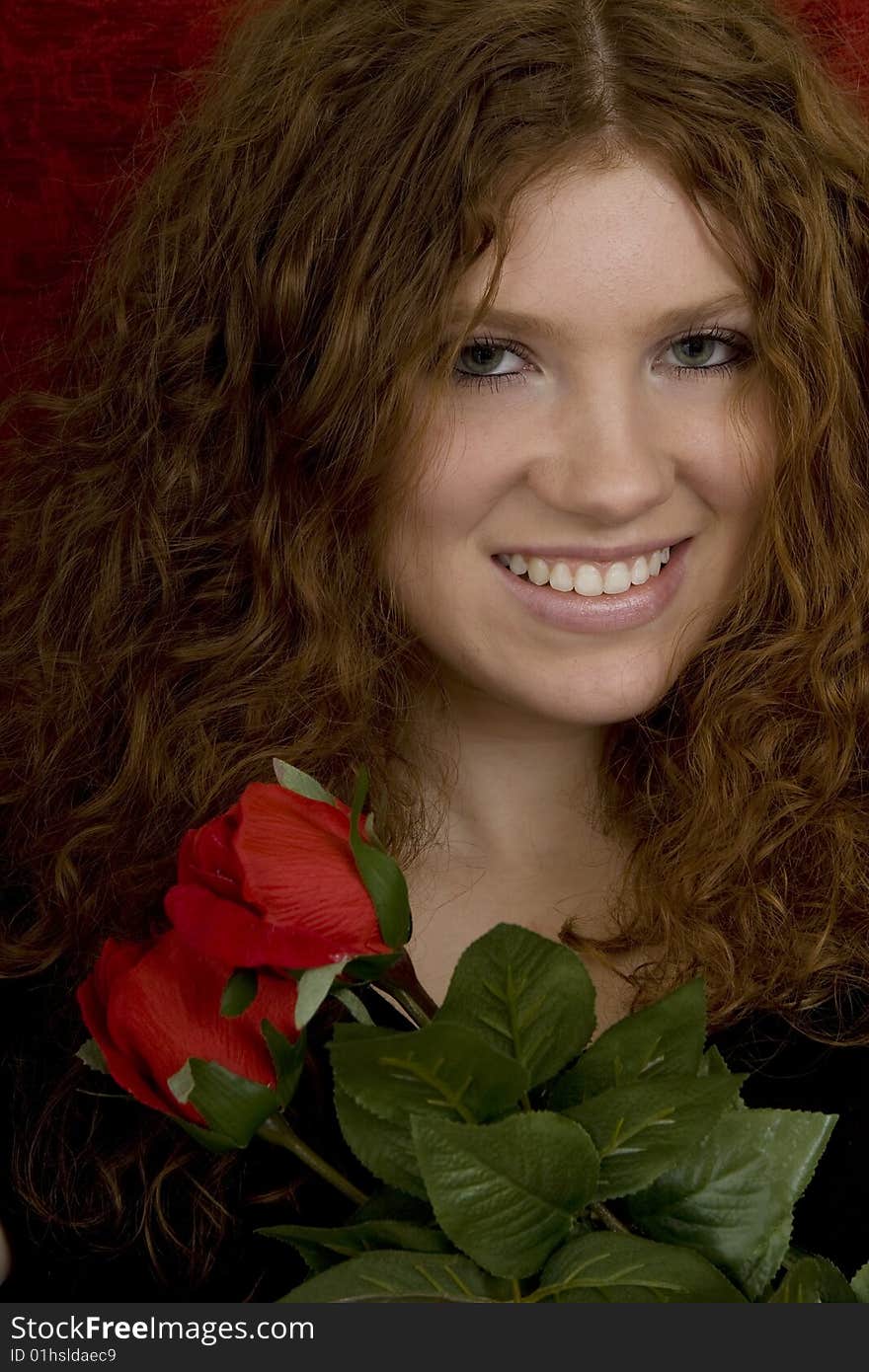 Red haired teenager with red roses, attractive youthful with long hair