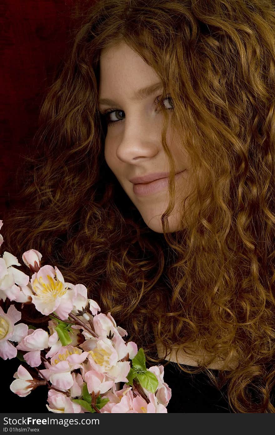 Red haired teenager with red roses, attractive youthful with long hair