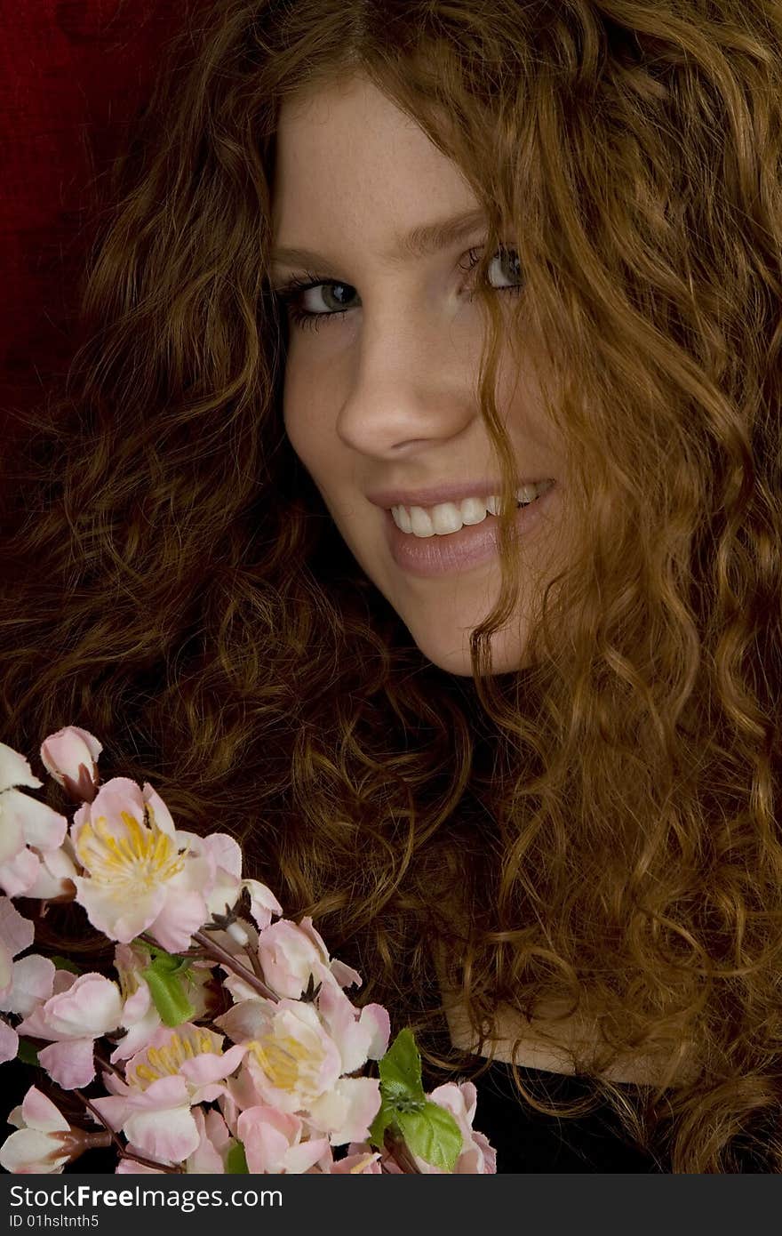 Red haired teenager with red roses, attractive youthful with long hair