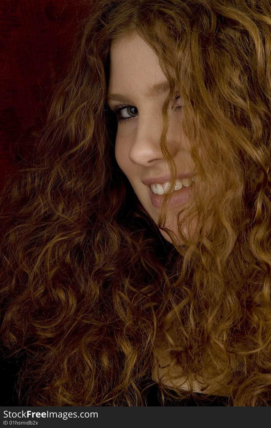 Attractive girl with long red hair, teenager with long curly hair