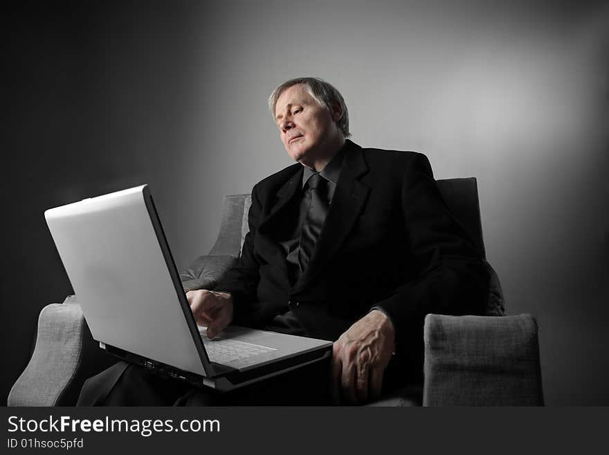 Portrait of a senior businessman using a laptop