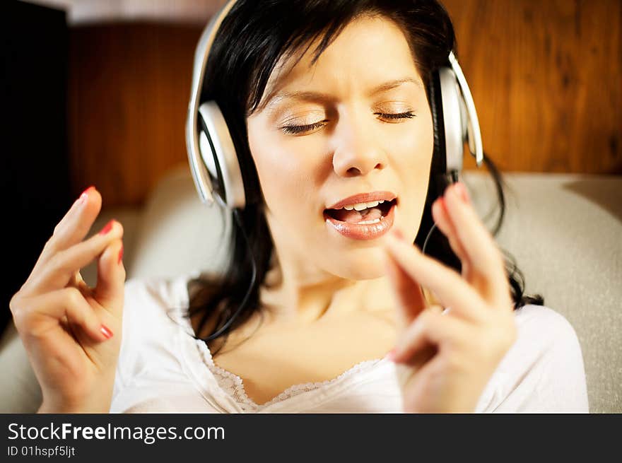 Beautiful woman listening music in headphones. Beautiful woman listening music in headphones