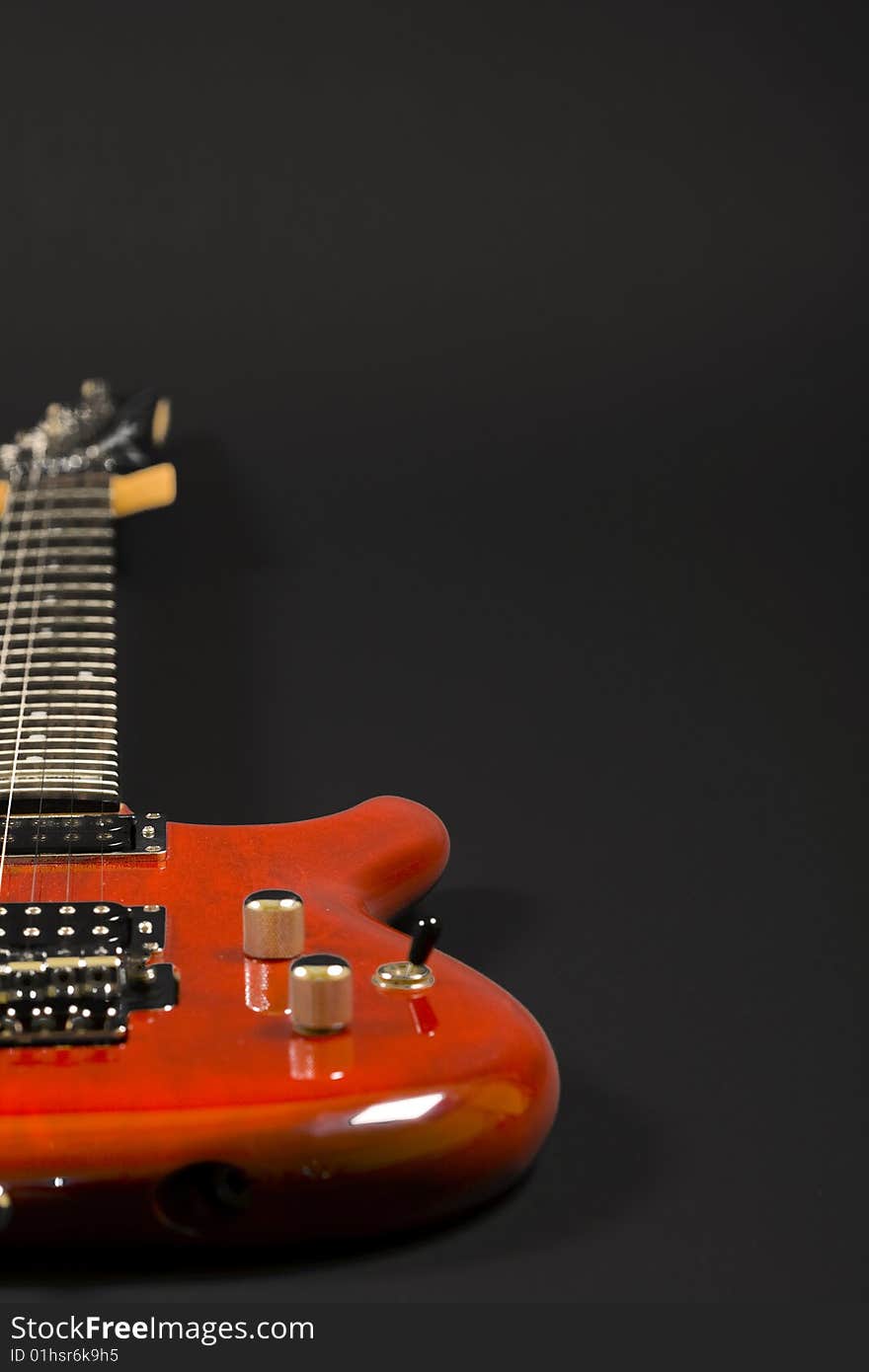 Closeup of an electric guitar over black