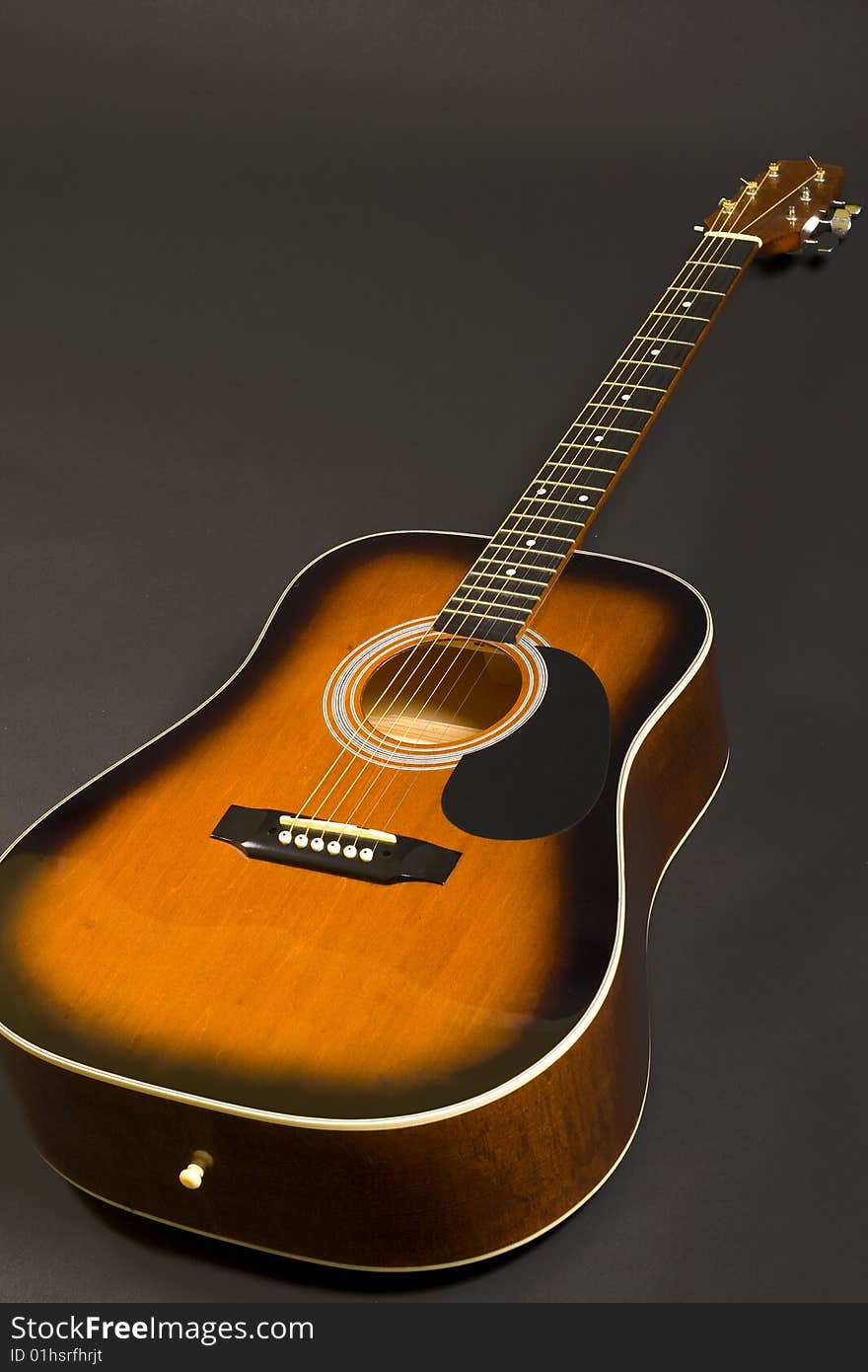 Closeup of an acoustical guitar over black