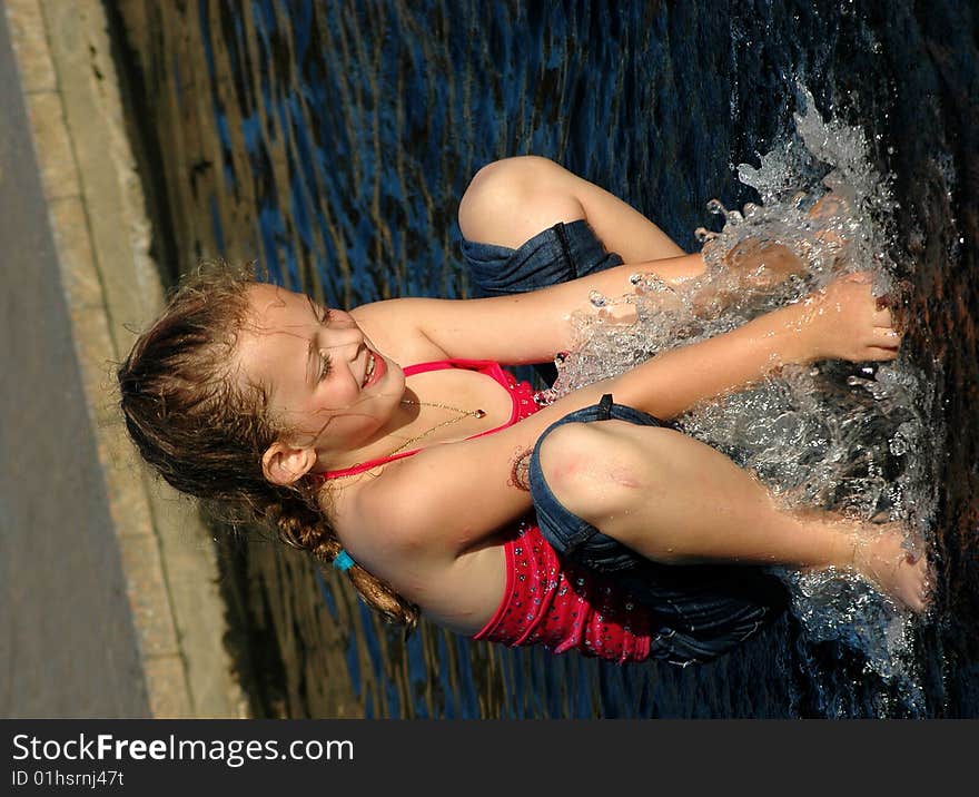 Girl playing in water fountain