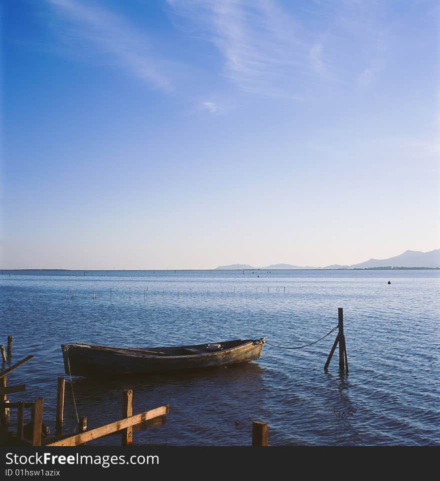 Fisherman boat in the middle of a blu quiet lagoon