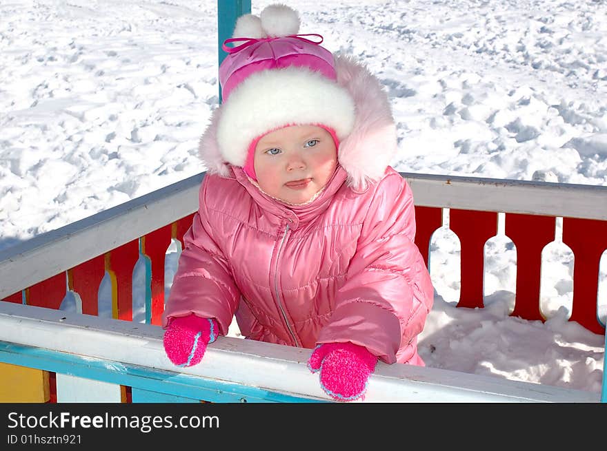 Pretty little girl in winter outerwear and winter playground. Pretty little girl in winter outerwear and winter playground.