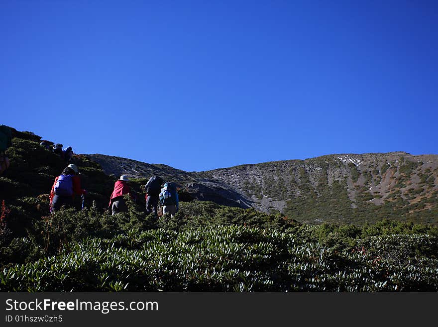 People with backpack trekking along the mountain