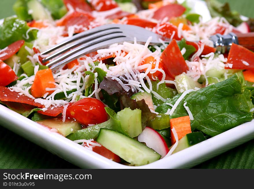 Close up of a delicious fresh garden salad with a fork. Close up of a delicious fresh garden salad with a fork