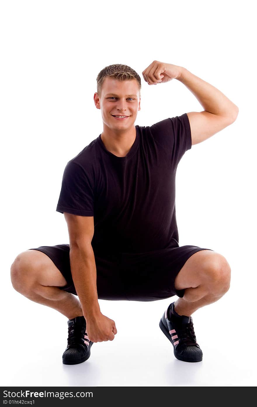 Sitting muscular man showing his muscles against white background