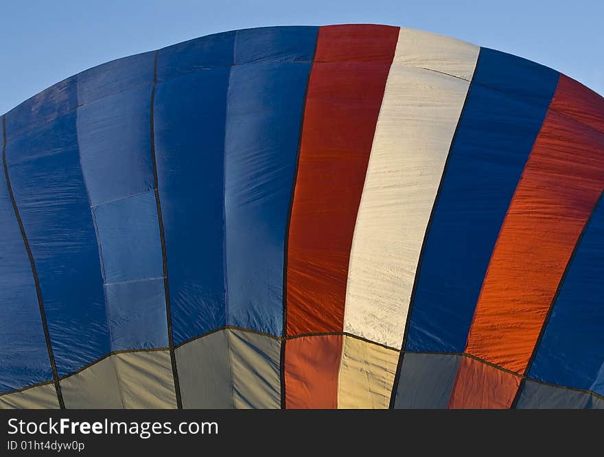 A red, white, and blue hot air balloon preparing for take-off. A red, white, and blue hot air balloon preparing for take-off.