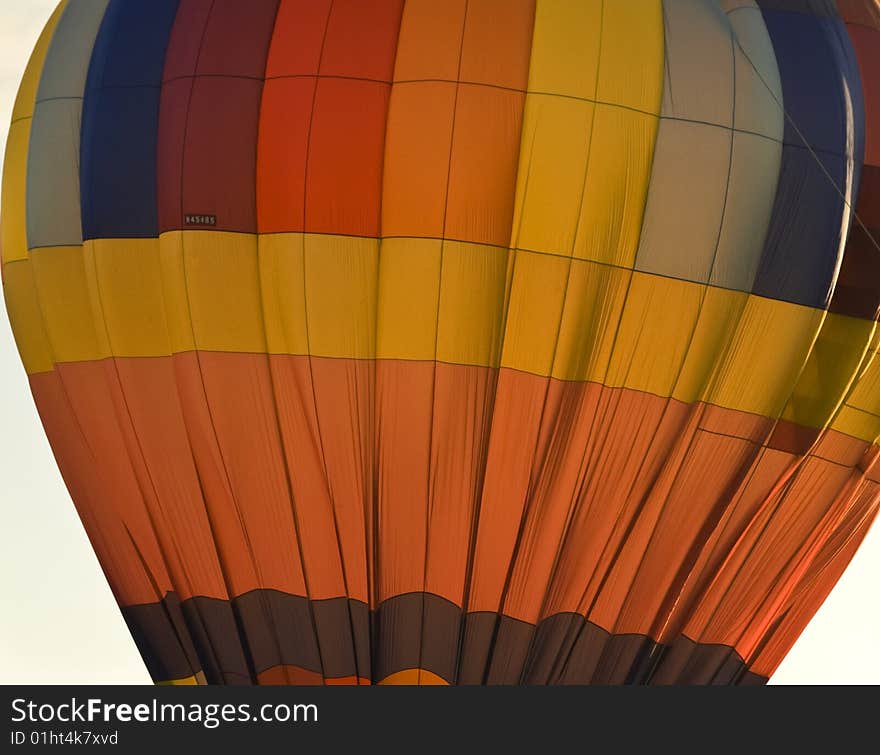 Hot air balloon, lit from behind, preparing for take-off. Hot air balloon, lit from behind, preparing for take-off.