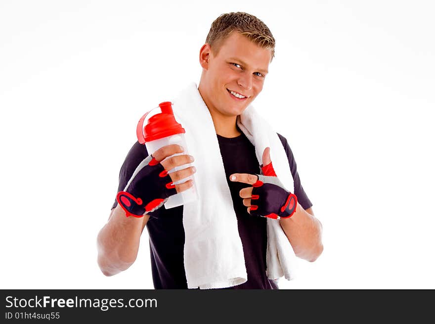 Smiling muscular man pointing at water bottle with white background