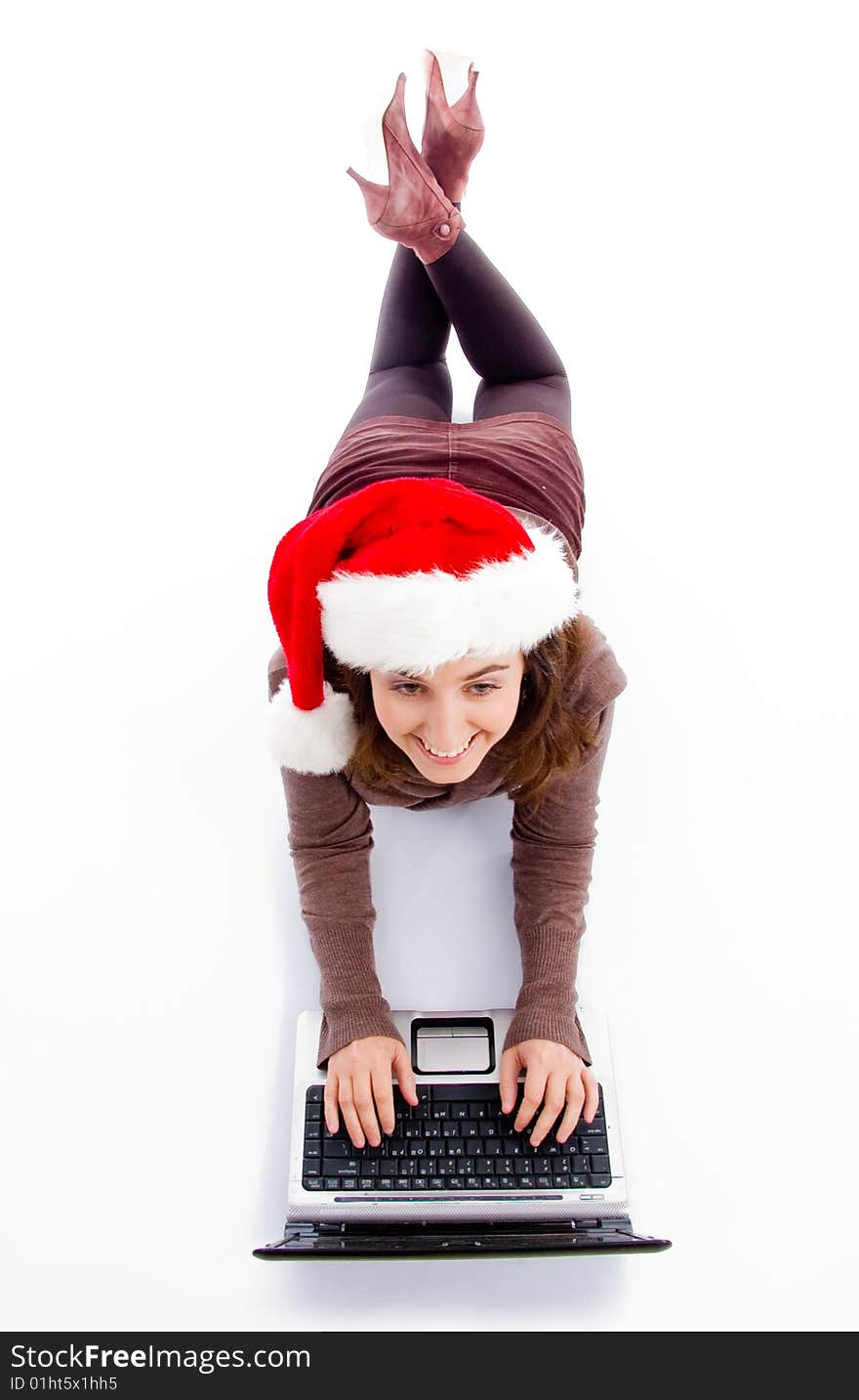 Female lying on floor working on laptop against white background