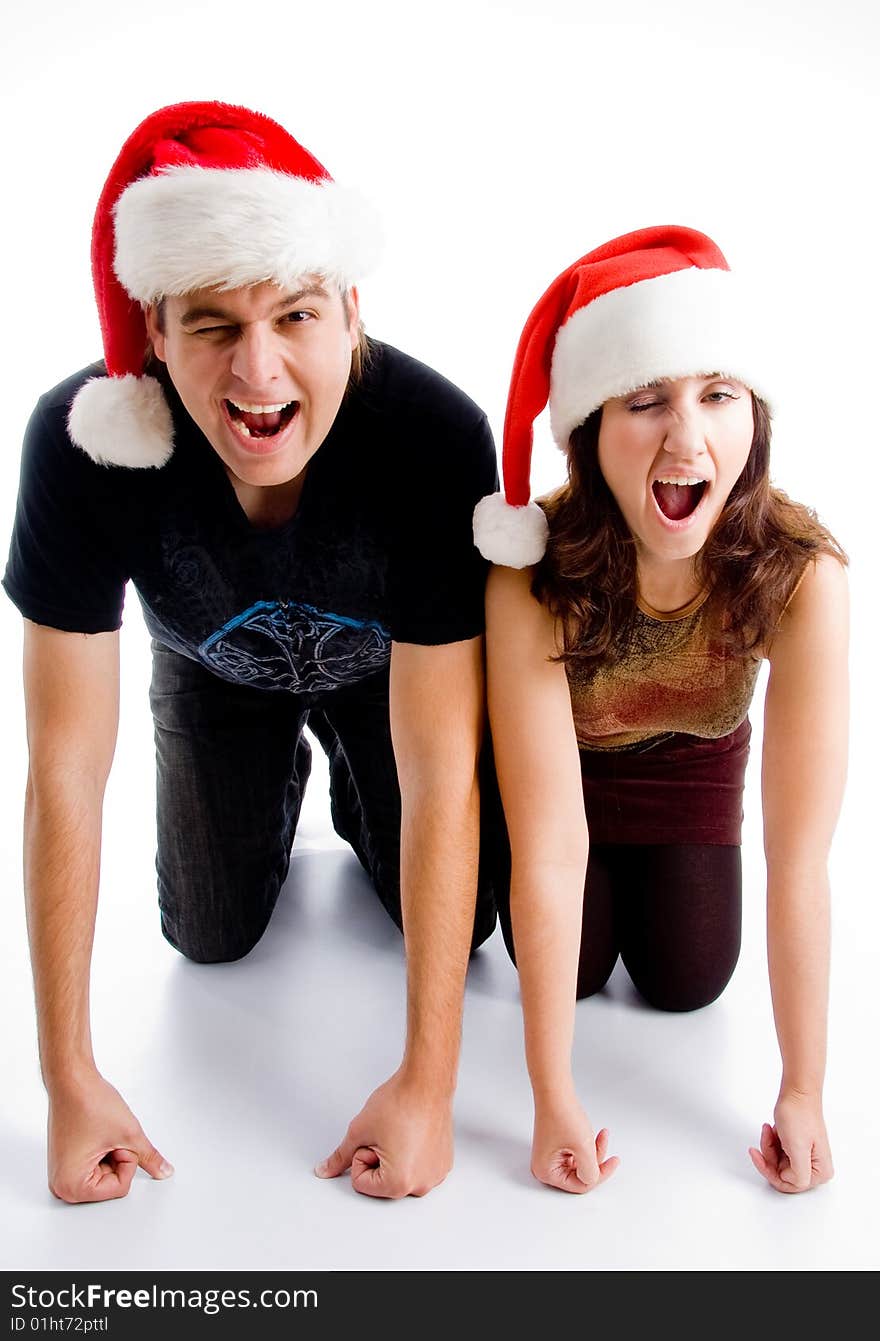 Winking young couple wearing christmas hat on an isolated white background